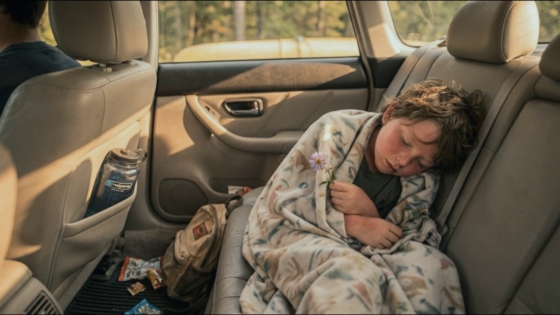 Subaru — kid asleep in backseat holding a flower